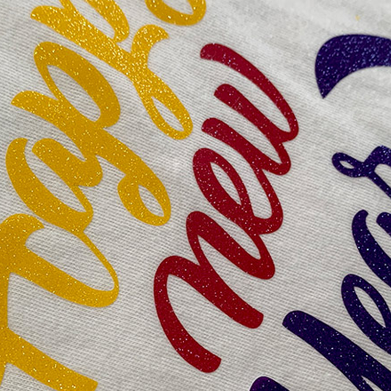 Prisma Sparkleshine Heat Transfer Vinyl on a design that reads "Happy New Year" in yellow, red, and blue.